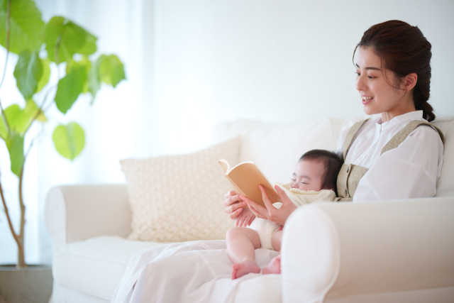 つわり中でも無理なく過ごそうと子どもと一緒に本を読む妊婦さん